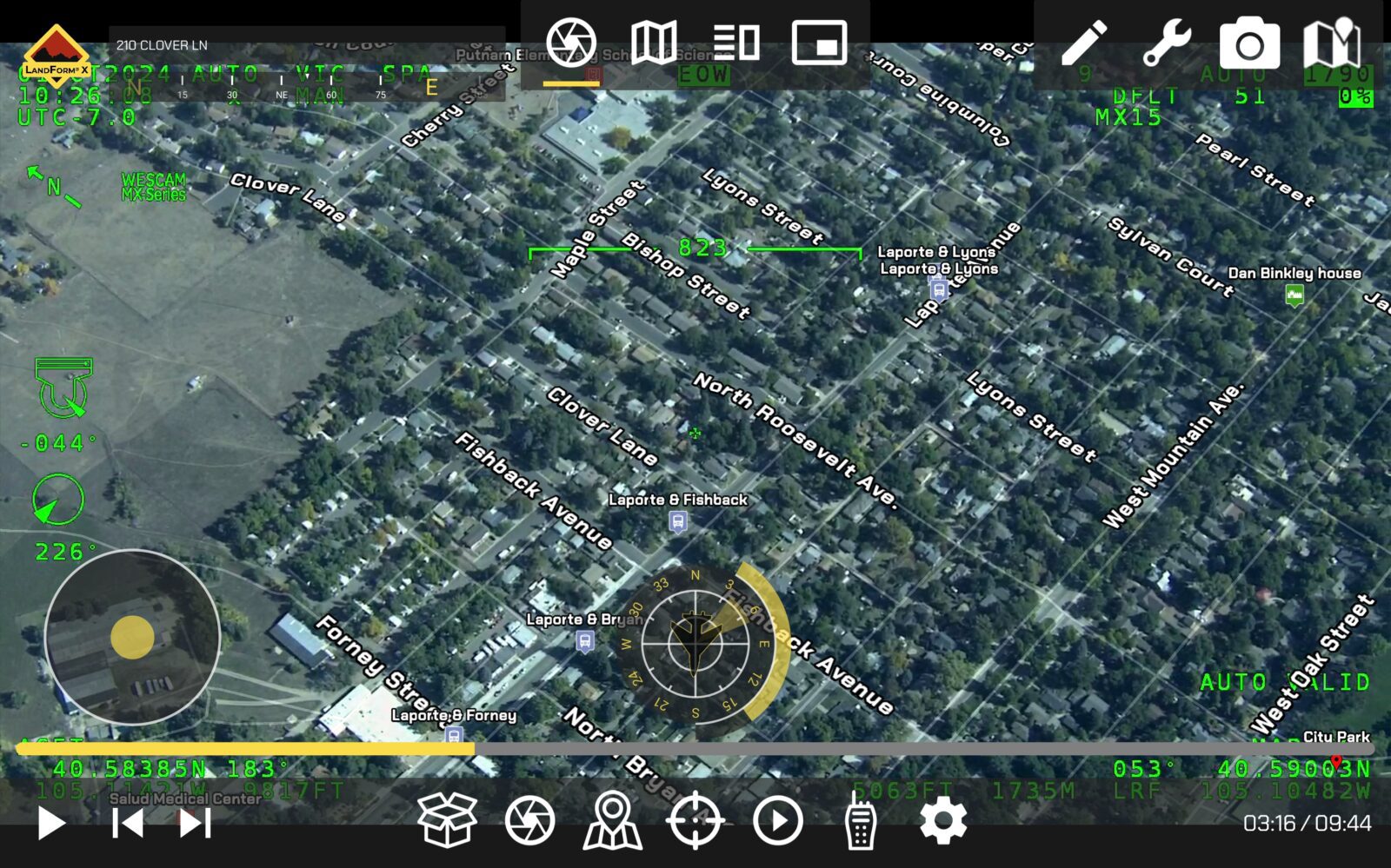 Aerial view of a residential area with street names overlay. Various interface elements and controls visible, suggesting a drone or aircraft display system.