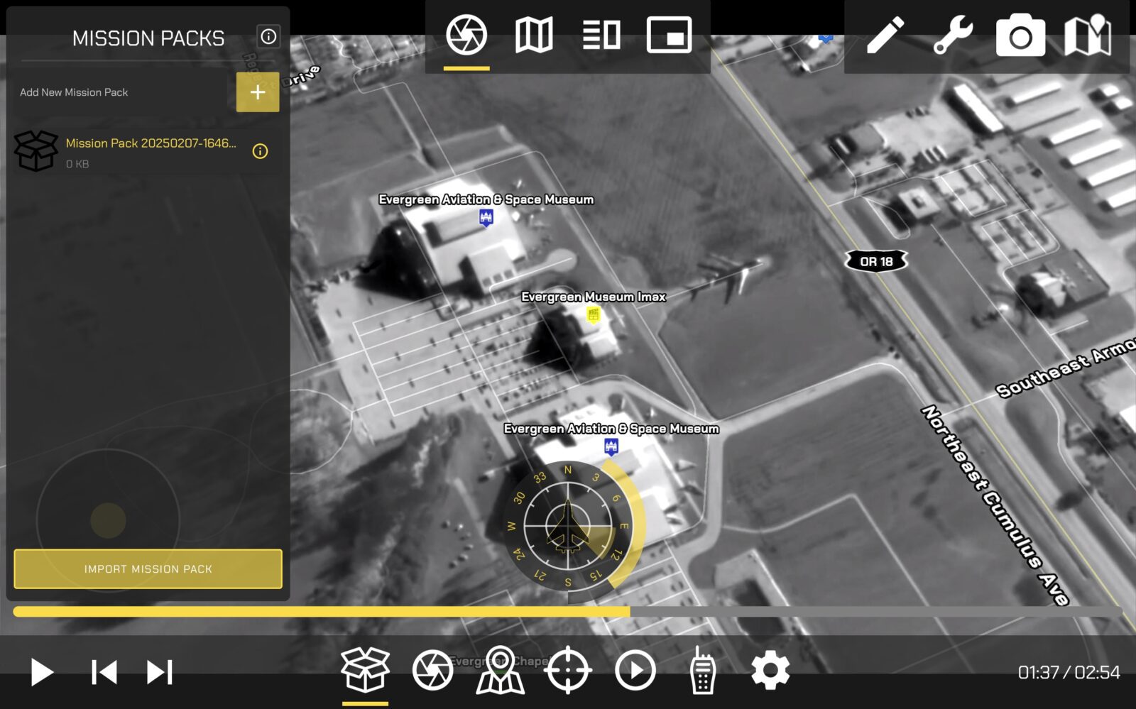Aerial grayscale map view displaying the Evergreen Aviation & Space Museum and surrounding area, with various interface icons and a mission pack menu overlaid on the screen.