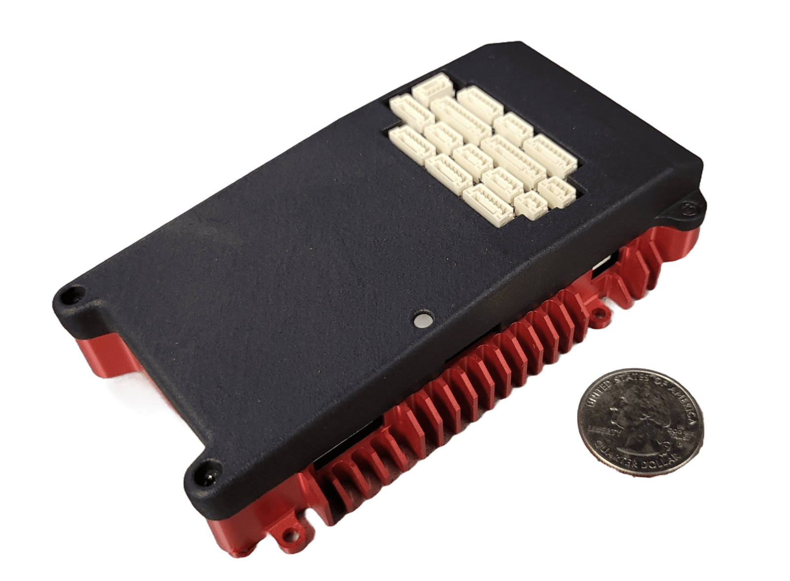 A black and red electronic circuit board is placed next to a U.S. quarter for scale.