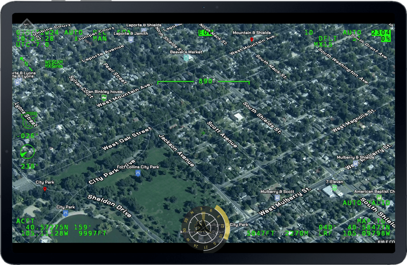 Aerial view of a suburban neighborhood with green on-screen navigation data overlay on a digital display.